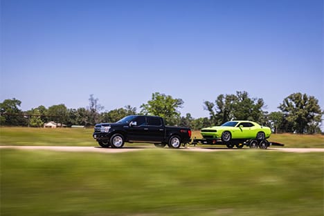 Pickup towing classic car.